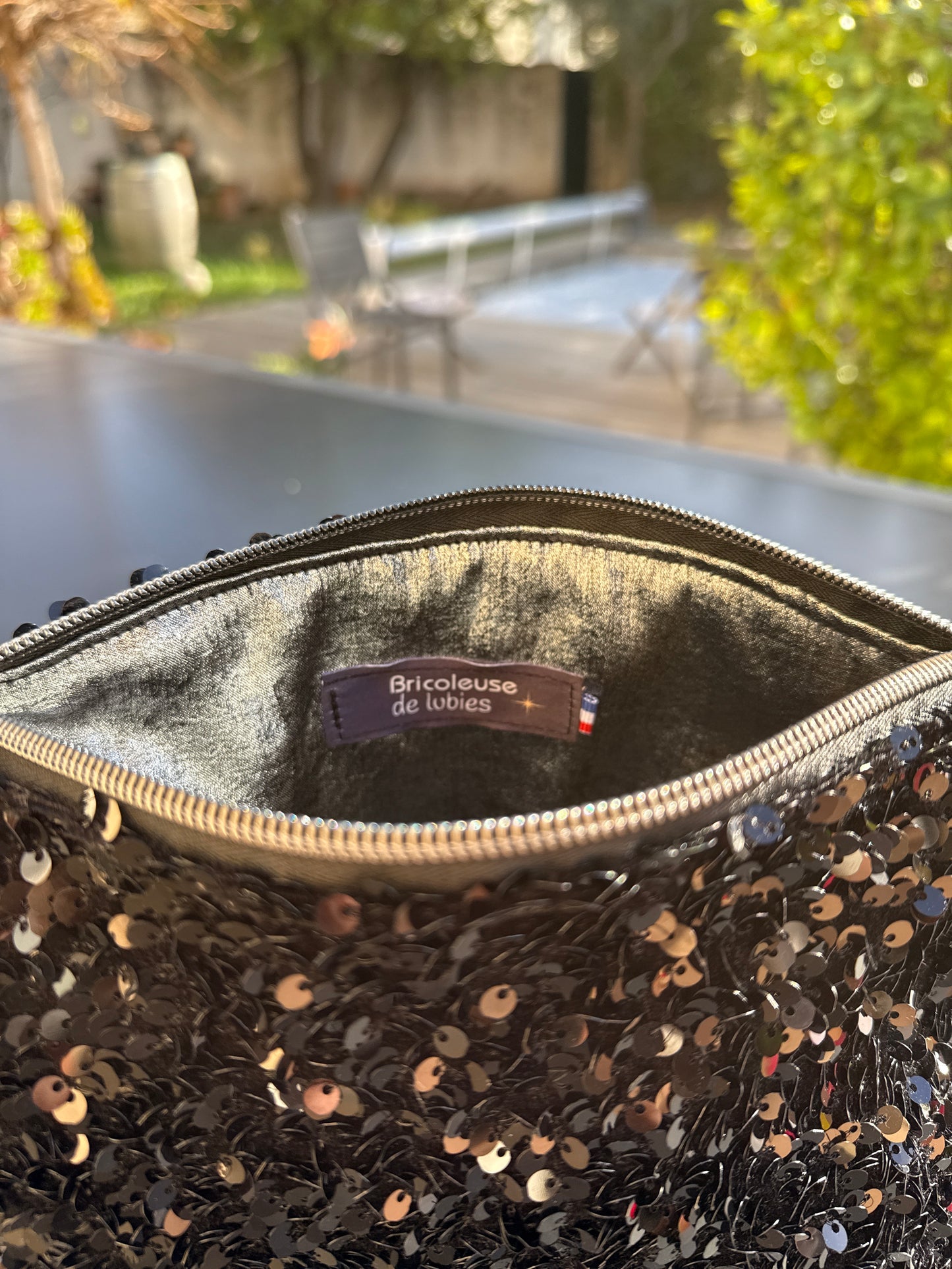 Pochettes sequins noirs avec boucles couleur argent